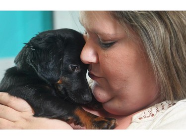 Jody Graves, a client of Calgary Urban Projects, holds her Dachshund Chihuahua cross Izzy Monday May 25, 2015. Izzy had a checkup and her shots through a community service learning program from the University of Calgary Faculty of Veterinary Medicine.