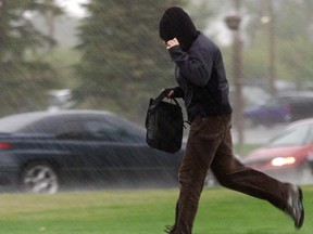 An unidentified man runs during a thunderstorm. (Grant Black/Calgary Herald)