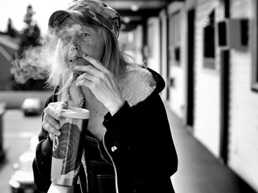 Homeless after years of addiction, Barbi Harris was dying of cancer. Here she smokes pot outside a low-budget motel.