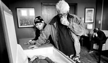 Hirsh, a fellow street person and a kindred spirit takes a moment to pay his last respects to Barbi Harris with two of her sisters.