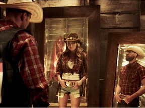 A frame grab from YouTube of the current 2015 Calgary Stampede ad called Buckle Up depicting a working cowboy and a woman wearing Daisy Duke shorts.