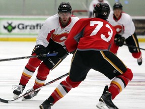 Flames rookies Hunter Smith and Keegan Kanzig go for the puck during the scrimmage at Winsport's ice complex, in Calgary on July 7, 2014.