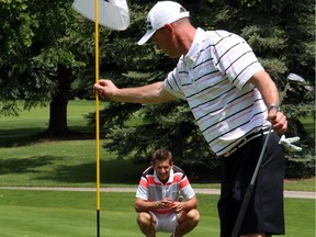 Jamie Welder studies the green as Kevin Temple clears the flag on the 16th hole at Calgary Golf & Country Club during the finals of the Calgary Golf Association's Rileys Best Ball tournament in 2014. Temple and Welder are the two-time defending champs in the main event.