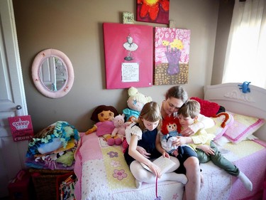 Tamara Gignac cuddles with her children Bronwyn, 7 and son Finn,4, at their home in Calgary.