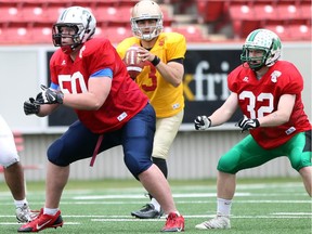 Brendan Barnes, 50, blocks for a quarterback as local football players from Grade 12 took to the field at McMahon Stadium while practicing for the annual Senior Bowl which takes place on Monday.