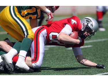 Bennett Thomson, Slotback from George MacDougal  High School in Airdire is brought down by Defensive Back Tony Savchuk of Jasper Place in Edmonton at the Alberta Senior Bowl all-star game between South all-stars and North all-stars at McMahon Stadium in Calgary.