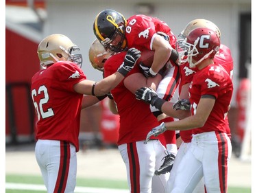 Slotback Duane Neustaeter of Olds gets a boost from his teammates after catching  a touchdown pass in the end zone at the Alberta Senior Bowl all-star game between South all-stars and North all-stars at McMahon Stadium in Calgary.