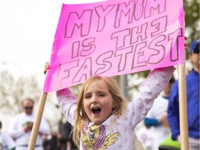 Madison Adams, six, cheers for her mom at the annual Mother's Day Run on Sunday, May 10, 2015.