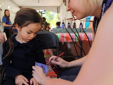 Chloe Feng-Logan, 4, got a butterfly air brushed on her arm by airbrush artist Natasha Michaud while visiting the Calgary International Children's Festival at Olympic Plaza on May 21, 2015.