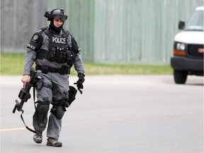 Calgary Police Service tactical unit members cleared the scene of an overnight standoff in Erin Woods on May 28, 2015.