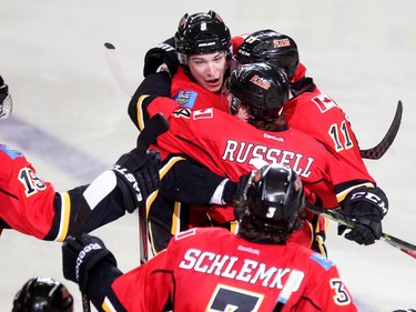 Calgary Flames players, from left, centrre Joe Colborne and defenceman Kris Russell celebrated with centre Mikael Backlund after he scored the game winning goal against the Anaheim Ducks during the overtime period NHL playoff action at the Scotiabank Saddledome on May 5, 2015. The goal gave the Flames their first win in the series.