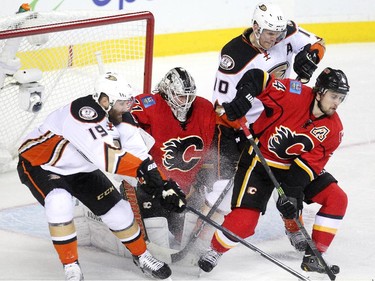 Calgary Flames goalie Karri Ramo got crowded in the crease by Anaheim Ducks left winger Patrick Maroon, left, and right winger Corey Perry as Flames defenceman Kris Russell tried to provide some support during first period NHL playoff action at the Scotiabank Saddledome on May 5, 2015.