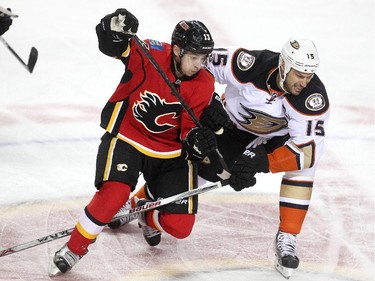 Calgary Flames left winger Johnny Gaudreau tried to skate away from a check by Anaheim Ducks centre Ryan Getzlaf during first period NHL playoff action at the Scotiabank Saddledome on May 5, 2015.