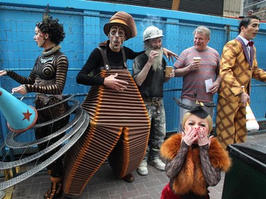 Cast members, from left, Klara the Telegraph of the Invisible, Nico the Accordion Man, Mini Lili and juggler Gabriel Beaudoin stopped to say hello to construction workers Joe Valiant, with hardhat, and Stuart LeBlanc.