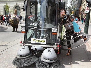 Cast member Klara the Telegraph of the Invisible checked her make-up in the mirror of a street cleaner as main cast members took to the streets of Calgary.