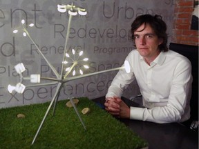 Canadian artist Michel de Broin sits next to a scale model of his work Bloom. The 23-metre sculpture is made of streetlights put together to represent a towering flower. It's set to be installed on St. Patrick's Island in time for the park's reopening this summer.