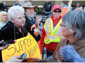 Gavin Young, Calgary Herald CALGARY, AB: MAY 07, 2015 - Angry seniors from left, Edith Vila, Bernie Taylor and Margaret Booth demand answers from Calgary City councillor Druh Farrell outside City Hall during a noisy protest on Thursday. The seniors say they their East Village Golden Age Seniors Club is being shut down with 30 days notice and no one seems to be able help them keep it open. Gavin Young/Calgary Herald)  (For City section story by Evan Radford) Trax# 00065062A