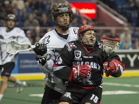 Jeremy Thompson of the Edmonton Rush cross checks Calgary Roughnecks star Shawn Evans during a game last month. The playoff battle between the two teams is expected to be intense.