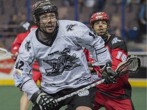 Mark Matthews of the Edmonton Rush runs towards a loose ball with Mike Carnegie of the Calgary Roughnecks at Rexall Place in Edmonton.