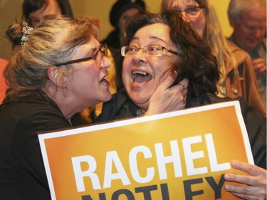 Two NDP supporters excitedly embrace after Rachel Notley is shown on a television feed at the Arrata Opera Centre in Calgary on Tuesday, May 5, 2015.