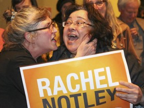 Two NDP supporters excitedly embrace after Rachel Notley is shown on a television feed at the Arrata Opera Centre in Calgary on Tuesday, May 5, 2015.