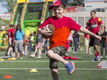 Austin Jeffrines, 6, tests out his ball running skills during the annual Stampeders Fanfest at McMahon Stadium in Calgary, on May 23, 2015.