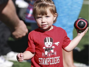 Brooklyn Biles, 2, tests out the ol' pig skin at the annual Stampeders Fanfest at McMahon Stadium in Calgary, on May 23, 2015.