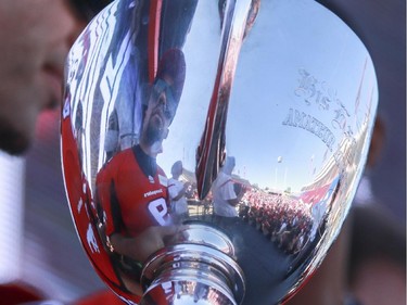 Calgary Stampeders Jon Cornish is reflected in the Grey Cup, along with the thousands of fans that hoped to meet the team and catch a glimpse of the Cup at the annual Stampeders Fanfest at McMahon Stadium in Calgary, on May 23, 2015.