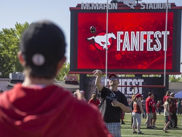 Father and son, Wayne Hoffarth, throwing ball, and Josh, 13, play catch with mini Stampeders football in the middle of the actual playing field during the annual Stampeders Fanfest at McMahon Stadium in Calgary, on May 23, 2015.