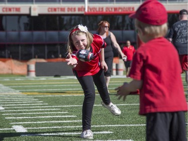 Jordis Dingwall, 8, tosses the football to her little brother Rider, 4, during the annual Stampeders Fanfest at McMahon Stadium in Calgary, on May 23, 2015.