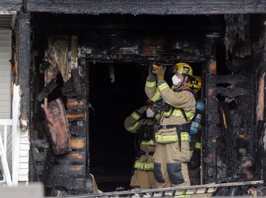 Firefighters check for hot spots after afire at a four-storey condo building in the 2200 block of 1st Street  S.W.