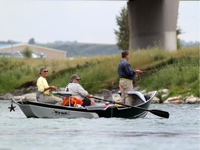 Colleen De Neve/ Calgary Herald CALGARY, AB --AUGUST 23, 2013 -- A couple of fly fishermen took to a boat to cast their lines in the waters of the Bow River near Fish Creek Park on August 23, 2013. (Colleen De Neve/Calgary Herald) (For City story by Val Fortney) 00047858C  SLUG: FLY FISHERMEN