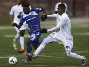 Foothills FC player Jean Pierre Rodriguez Lemos, right, runs after a Edmonton FC play on Stampeder Field at Shouldice Park in Calgary on Saturday, April 25, 2015. The Foothills FC soccer club lost to the Edmonton FC, 3-1, in an exhibition game.