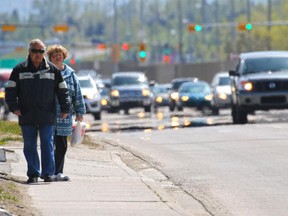 Pedestrians walk a section of sidewalk along Macleod Trail on Monday May 18, 2015.