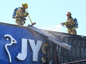 Calgary firefighters search for hot spots after quickly knocking down a two alarm fire behind the JYSK store in Heritage Meadows Wednesday afternoon.