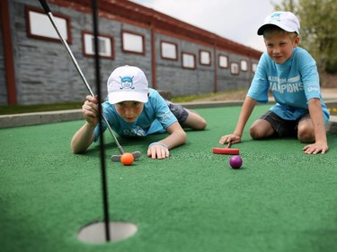 Nicholas Moroz, 14, left, and his brother Jacob,12, representing Classroom Champions, play a round of mini golf during the Shaw Charity Classic press conference in Calgary on May 26.