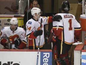 Calgary Flames' Jiri Hudler, centre, of the Czech Republic, taps the shoulder of goalie Jonas Hiller, of Switzerland, after Hiller was relieved after giving up three goals to the Anaheim Ducks during the second period of Game 1 in the second round of the NHL Stanley Cup hockey playoffs, Thursday, April 30, 2015, in Anaheim, Calif.