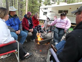 A Cochrane family sat around the campfire on the May long weekend to keep warm and dry while camping at the McLean Creek Campground. All open fires in forested areas are now banned.