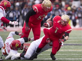 Laval Rouge et Or offensive lineman Karl Lavoie, middle knocks over Calgary Dino Thomas Spoletini on a running play from Maxime Boutin in the 2013 Vanier Cup. Lavoie is now a Calgary Stampeders prospect, picked ninth overall in the first round on Tuesday night.