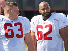 Calgary Stampeders offensive linemen Pierre Lavertu, left, and Edwin Harrison wait to for a drill during the first day of the Calgary Stampeders training camp at McMahon Stadium on Sunday.