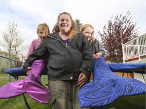 Tabatha Christenson, left, with Mom Shelly and sister Marissa show off hand-made mermaid tails at their home in Calgary on Wednesday, May 13, 2015. Christenson creates the tails for use in costumes and for swimming.