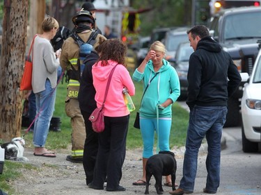 Residents wait as firefighters check for hot spots following a two-alarm fire at a four-storey condo building in the 2200 block of 1st Street S.W.