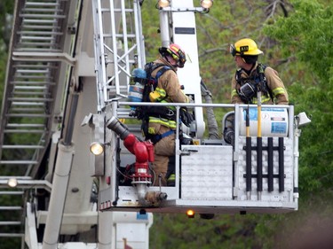 An aerial basket raises firefighters above the scene as Calgary Fire Fighters worked to extinguish hot spots following a two-alarm fire at a four-storey condo building in the 2200 block of 1st Street  S.W.