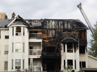 Firefighters check for hot spots following a two-alarm fire at a four-storey condo building in the 2200 block of 1st Street S.W.