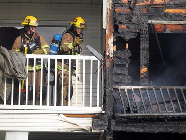 Firefighters check for hot spots following a two-alarm fire at a four-storey condo building in the 2200 block of 1st Street S.W.