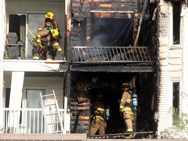 Firefighters check for hot spots following a two-alarm fire at a four-storey condo building in the 2200 block of 1st Street S.W.