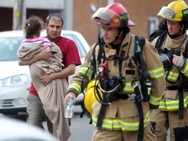 Residents wait as firefighters check for hot spots following a two-alarm fire at a four-storey condo building in the 2200 block of 1st Street  S.W.