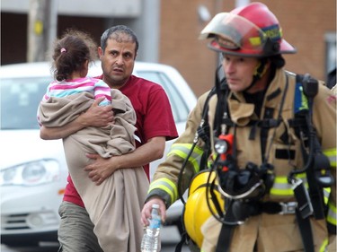 Residents wait as Calgary Fire Fighters checked for hot spots following a 2 alarm fire at a four-storey condo building in the 2200 block of 1st Street  SW  on May 26, 2015. At least four units received extensive damage.