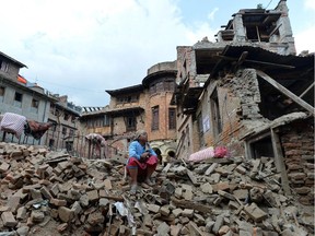 A Nepalese resident sits in the ruins of a collapsed house after an earthquake in Baktarpur on the outskirts of Kathmandu on May 20, 2015. Nearly 8,500 people have now been confirmed dead in the disaster, which destroyed more than half a million homes and left huge numbers of people without shelter with just weeks to go until the monsoon rains.