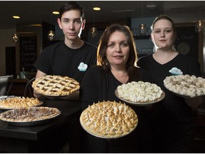 Maureen DePatie, owner  of Pie Cloud, centre, with her children Mason,18, and Mackenzie, 22, hold Luscious Lime, Lemon Meringue, Apple Pie and Banana Cream pie respectively at the newly opened restaurant  in the Kensington area of Calgary